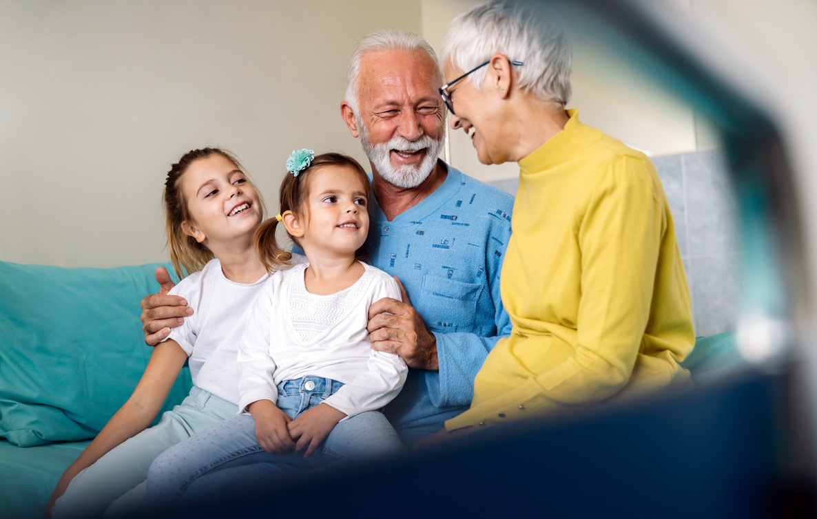 Happy grandchildren visiting grandfather at hospital ward. Support, family and healthcare concept.